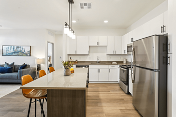 A modern kitchen with a large island and stainless steel appliances.